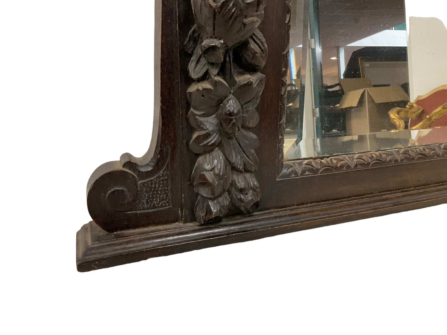 Victorian heavily carved oak wall mirror, projecting gadroon carved ovolo cornice, bevelled mirror plate within a lunette carved frame, decorated with applied fruit and foliage carved mounts, scroll carved brackets 