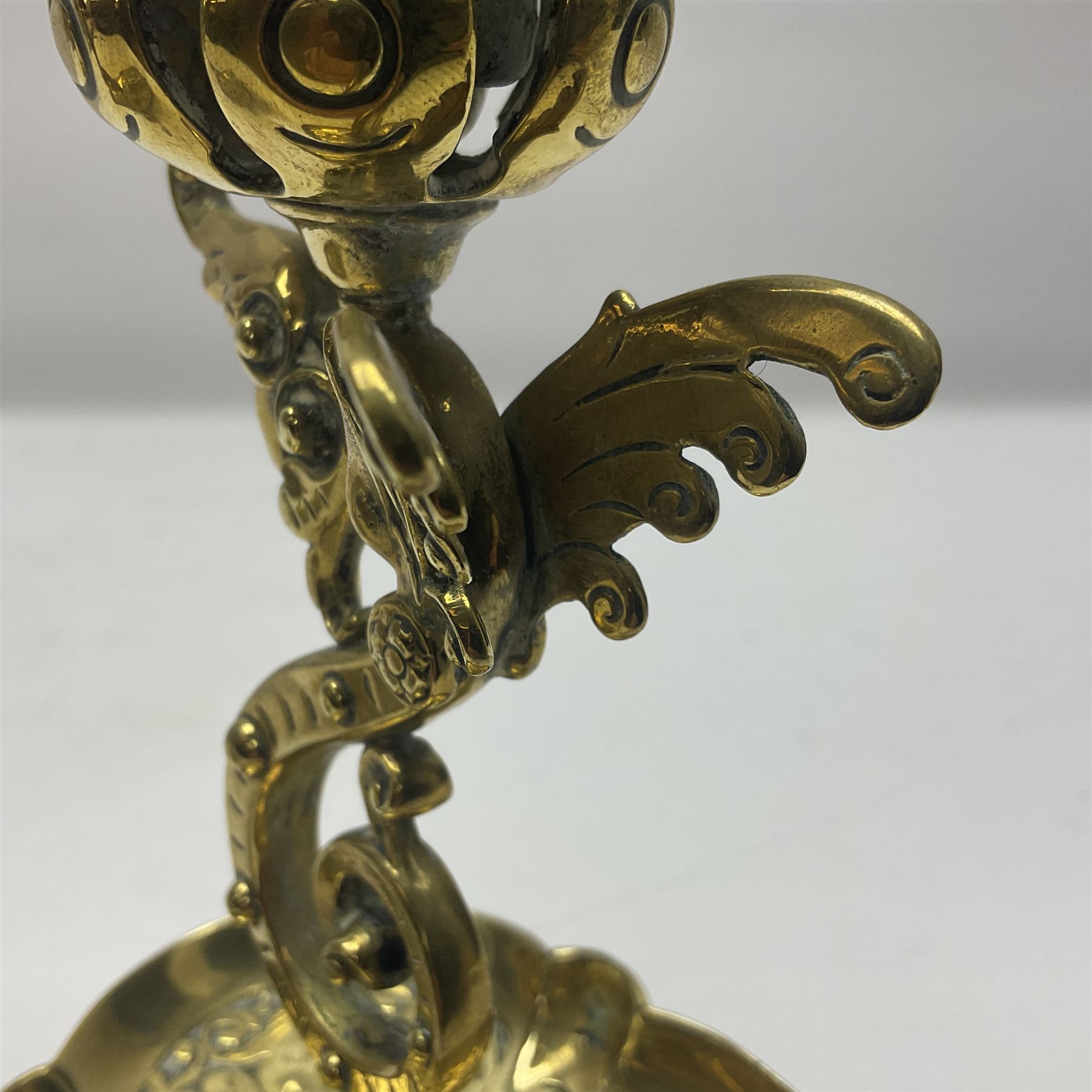 Pair of Victorian brass candlesticks by Adolf Frankau & Co, each with pierced sconce upon a scrolling stem with winged mask decoration, the lobed drip pan embossed with masks and upon three scrolling feet, stamped with maker's mark beneath, H18cm