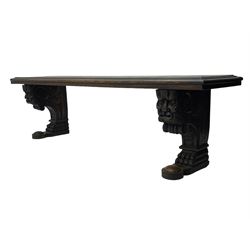 Victorian oak bench, moulded rectangular top, on mask and scroll carved corbel supports with paw feet, rectangular platforms with rounded terminals and applied roundel 