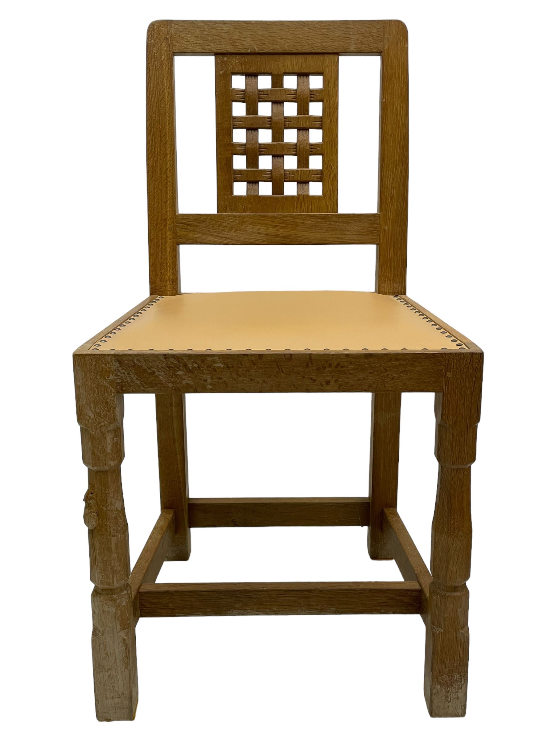 Mouseman - set of six oak dining chairs, pierced and carved lattice panel back over tan leather seat with studded band, on octagonal front supports united by plain H stretchers, carved with mouse signature, by the workshop of Robert Thompson, Kilburn 