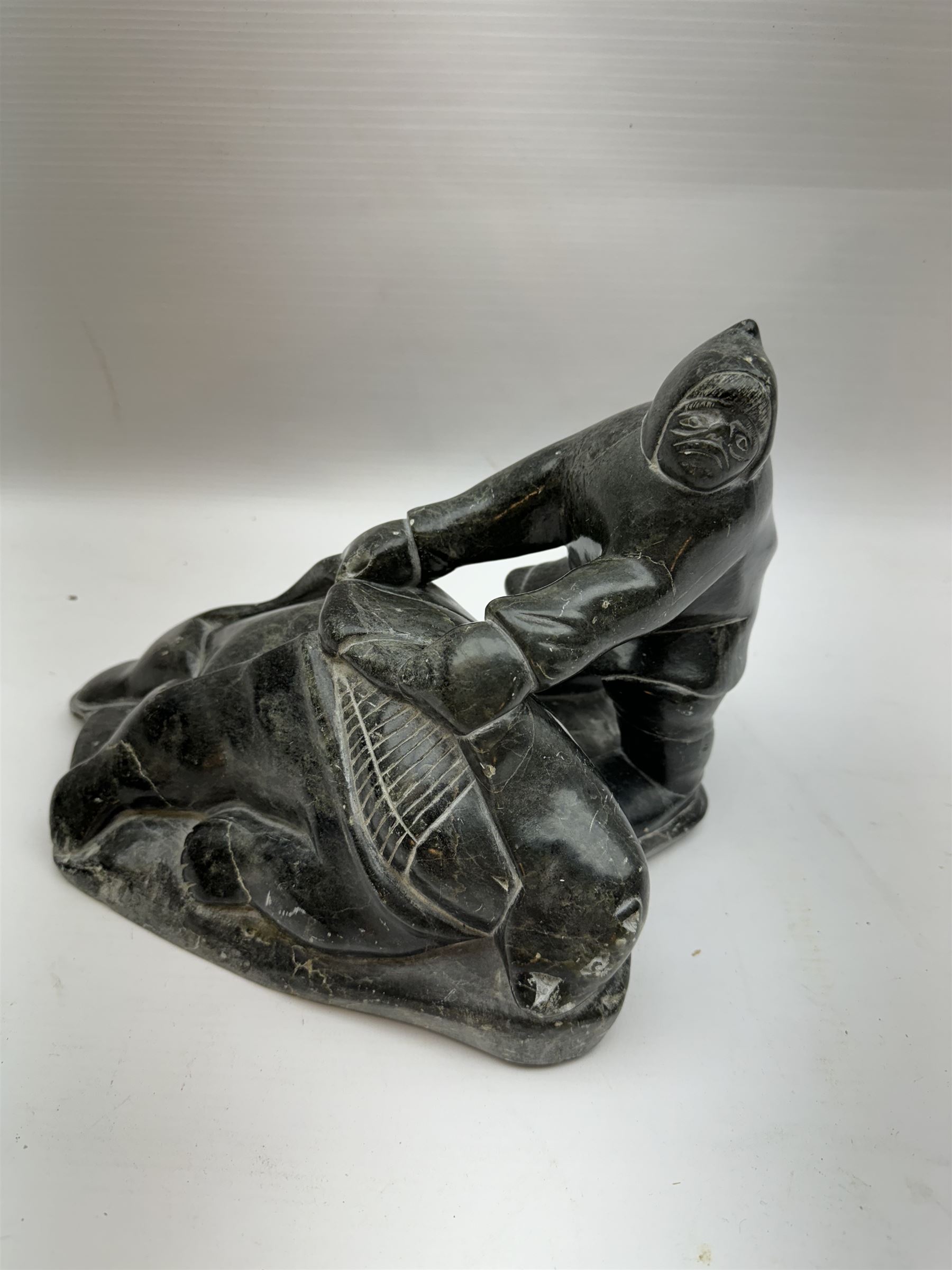 Inuit soapstone carving, of a hunter and a polar bear, circa 1960, H19cm 