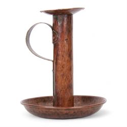 Large Arts & Crafts copper chamberstick, the circular dish with tall cylindrical stem, circular nozzle, and applied strap handle, the whole with hammered finish, with impressed mark beneath, H22cm