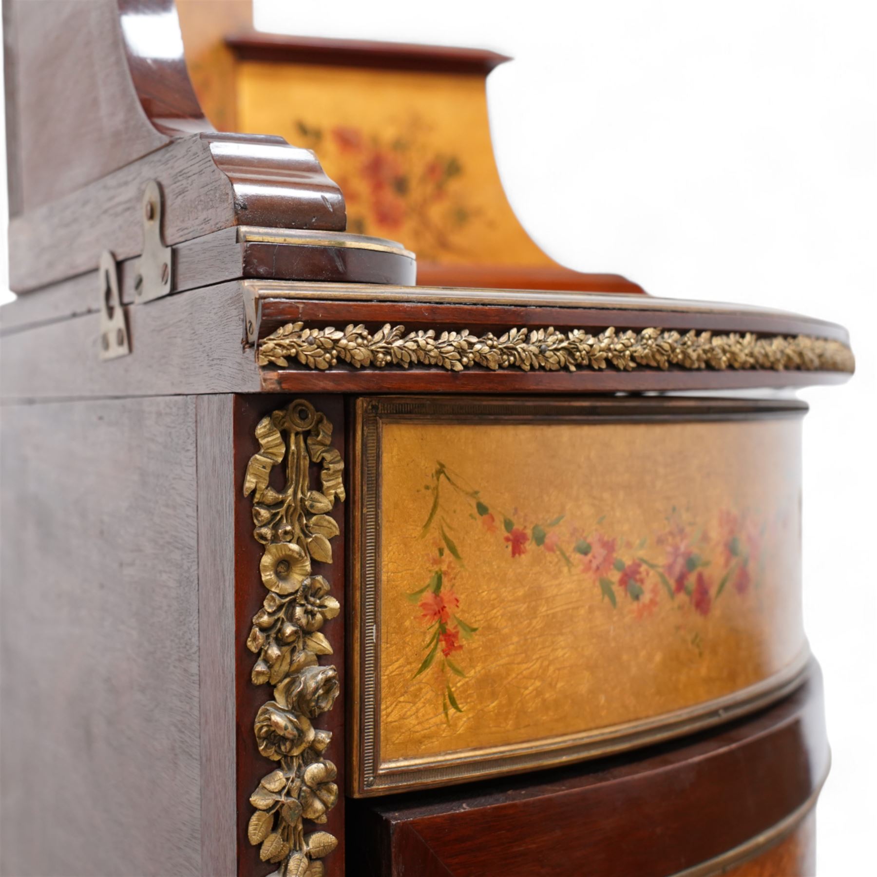 Mid-to-late 20th century mahogany and gilt metal mounted corner cupboard, raised back with floral decoration surmounted by laurel leaf wreath, single hinged drawer decorated with floral festoons, enclosed by single door with Vernis Martin design panel, on out splayed feet with foliate mounts 