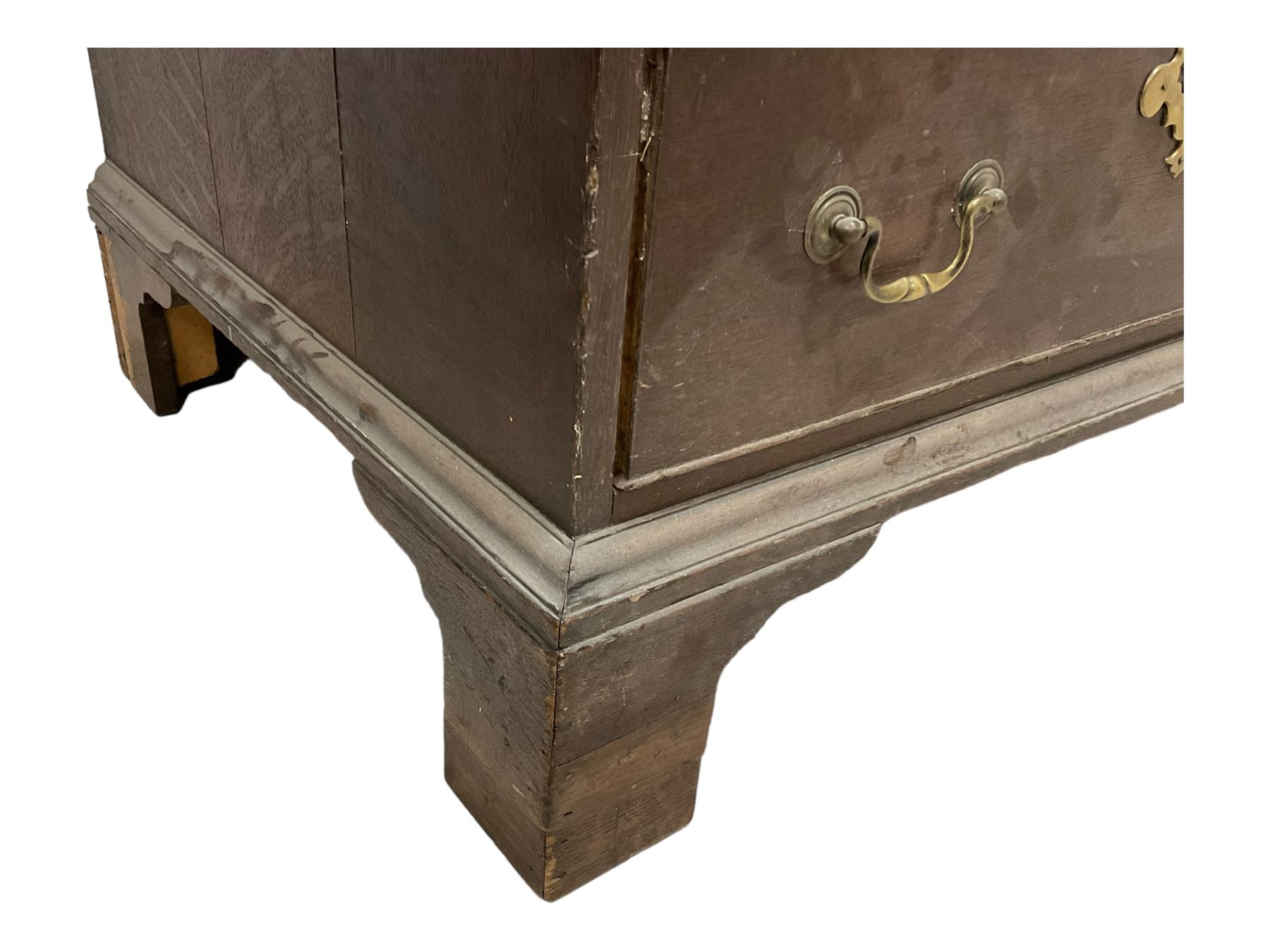 18th century oak linen press, moulded cornice over two panelled cupboard doors, the base fitted with two cock-beaded drawers with pieced brass escutcheons and handles, lower moulded edge on bracket feet