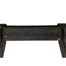 19th century Elizabethan design carved oak fire surround, reverse break-front lintel over egg and dart moulded upper edge, the ovolo-moulded frieze carved with scrolling leafy branches, central cartouche and putti riding dolphins, the uprights carved with female masks over carved busts, square tapering pilasters carved with ribbon tie over trailing fruit, on stepped moulded base 