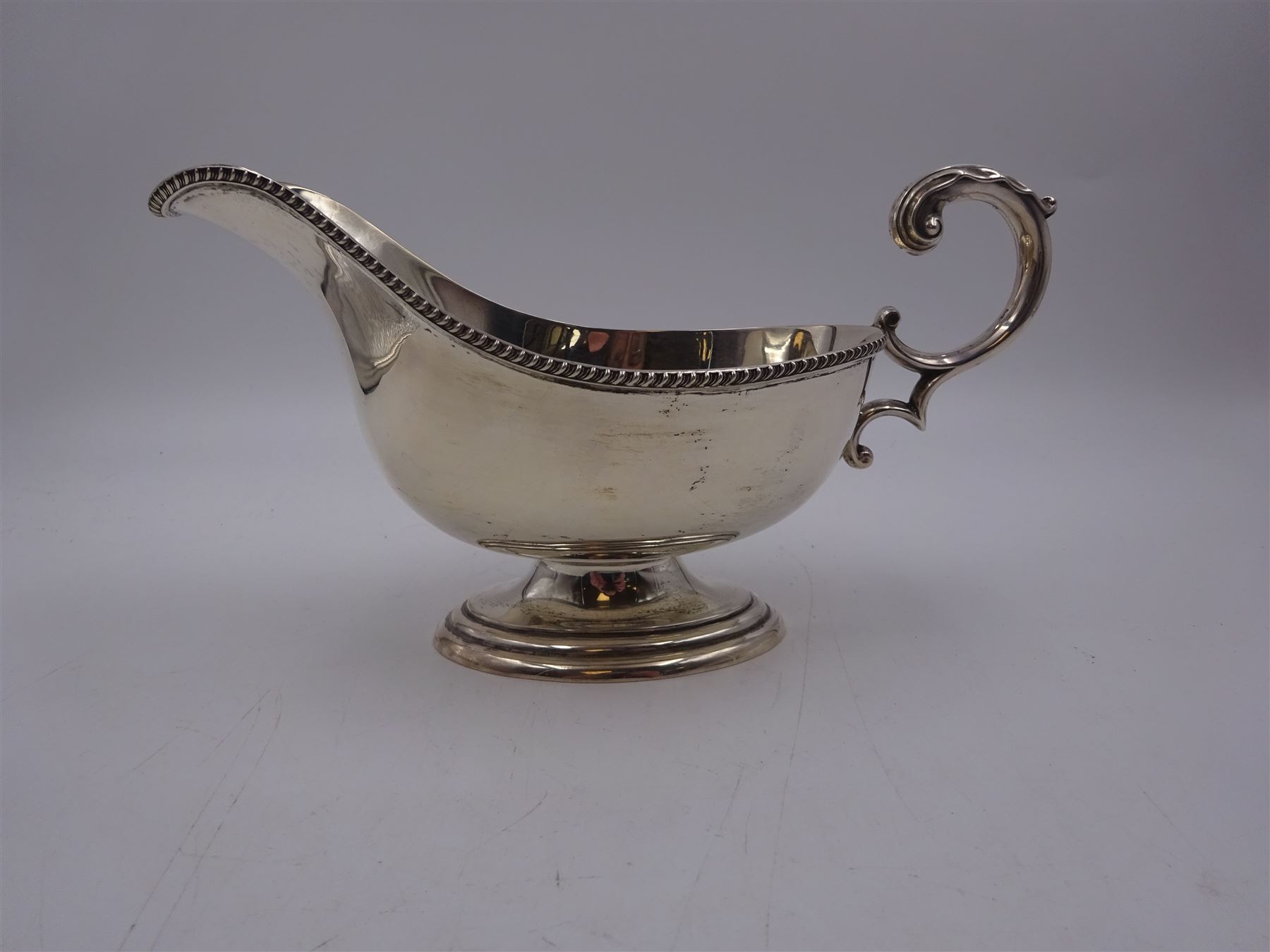 1930s silver sauce boat, of typical form, with oblique gadrooned rim and acanthus capped flying C scroll handle, by William Hutton & Sons Ltd, Sheffield 1934, H11cm