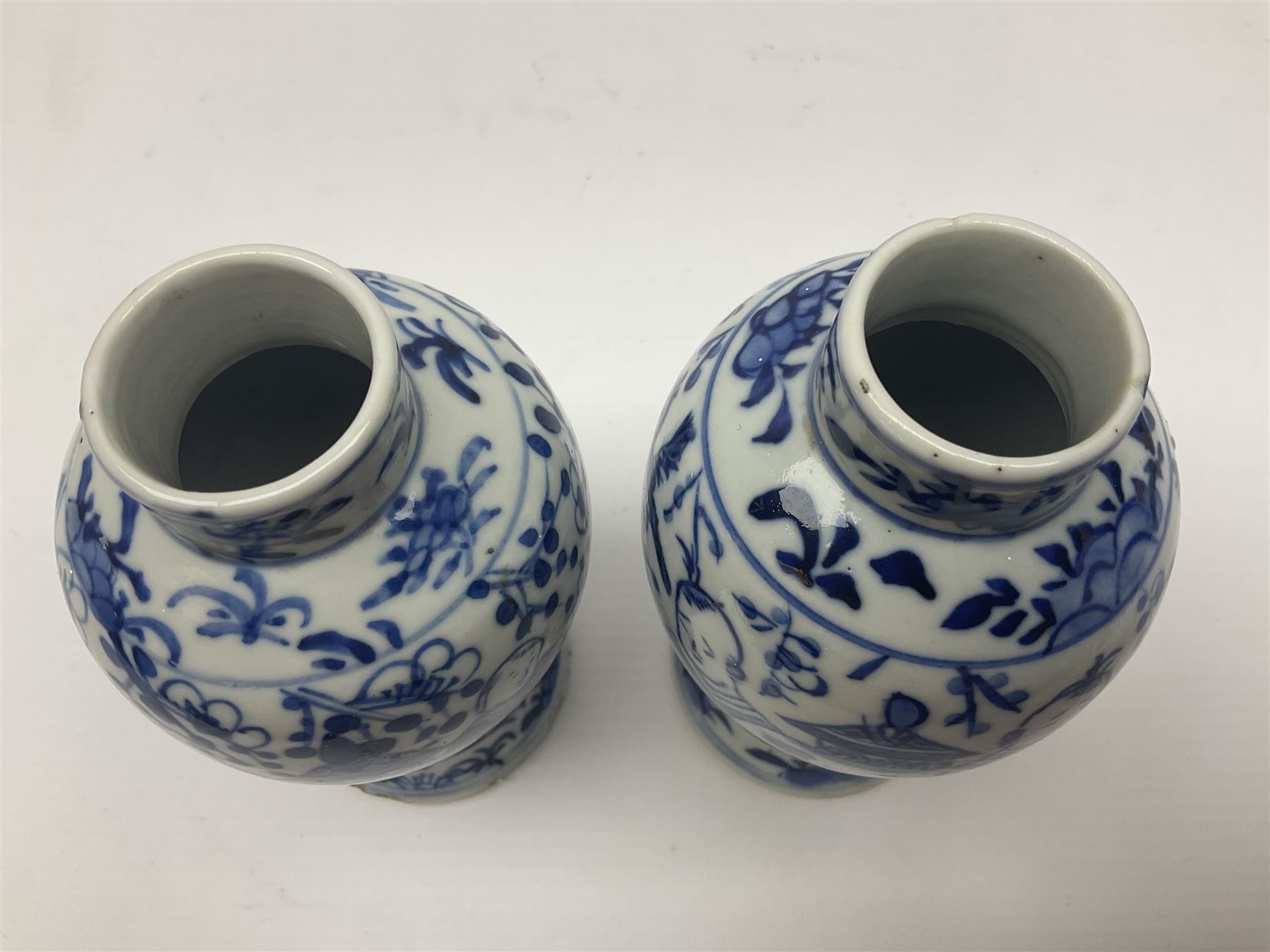 Pair of Chinese blue and white vases, of squat baluster form, each depicting figures holding a ginger jar, with four character Kangxi mark beneath, H13.5cm