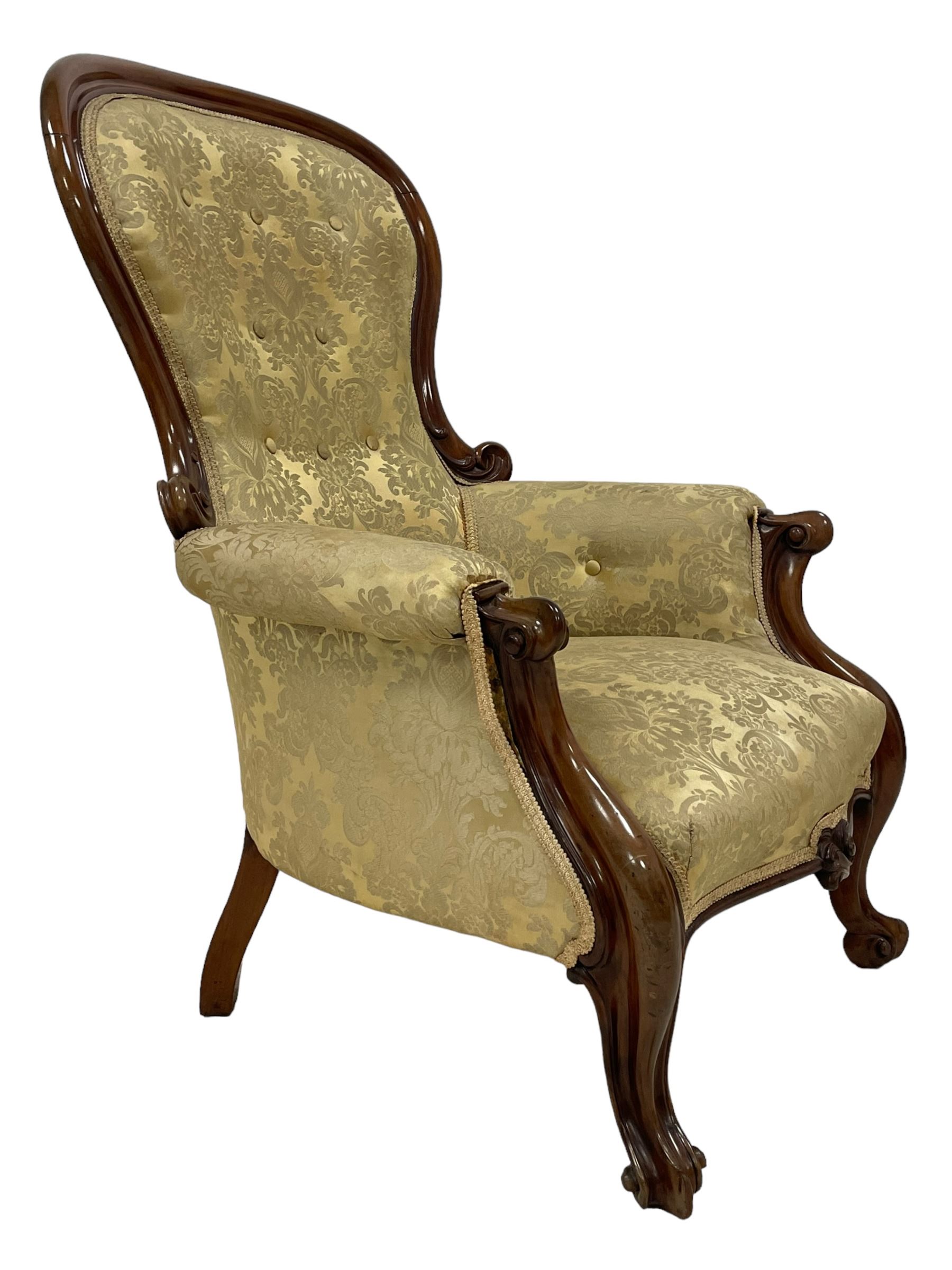 Victorian mahogany framed armchair, shaped and moulded frame carved with curled foliage, upholstered in pale gold floral pattern silk damask fabric, scrolled arm terminals on shaped moulded supports terminating to scroll carved feet