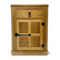 Mouseman - oak floor standing corner cupboard, fall front compartment over single panelled door, with wrought metal loop handle and latch, on moulded plinth base, carved in relief with mouse signature, by the workshop of Robert Thompson, Kilburn 