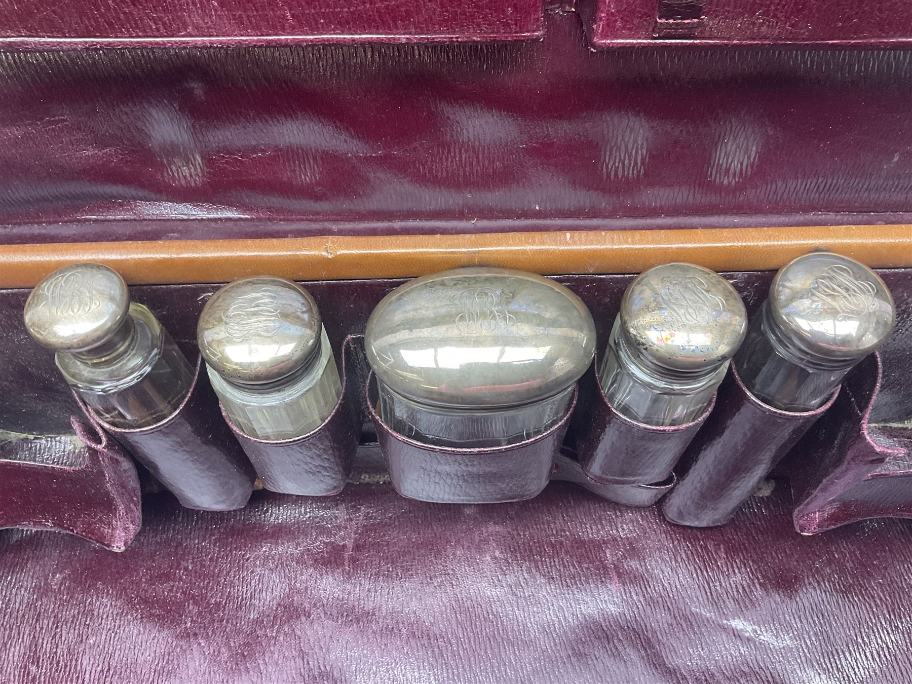 Early 20th century leather bound travelling case, with initials to cover, with fitted interior containing five silver topped glass jars, each engraved with initials, hallmarked The Alexander Clark Manufacturing Co, London 1910 & 1911, case W61cm