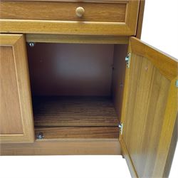 Mid 20th century teak bureau, sloped fall-front opening to reveal fitted interior with compartments, over panelled full width drawer and two cupboard doors, on recessed plinth base