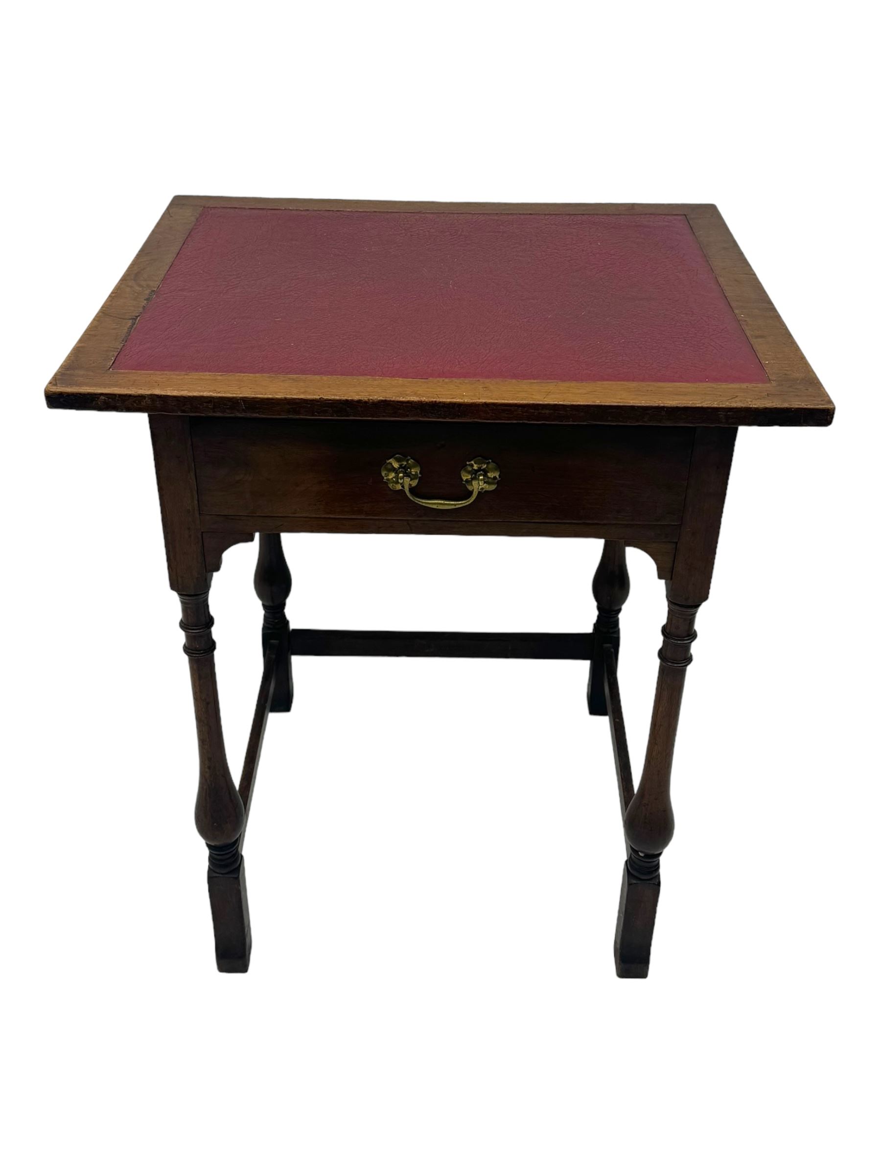 Early 20th century oak walnut lamp or side table, rectangular top with red leather insert, over single drawer with felt lining and brass handle, raised on turned supports with stretchers