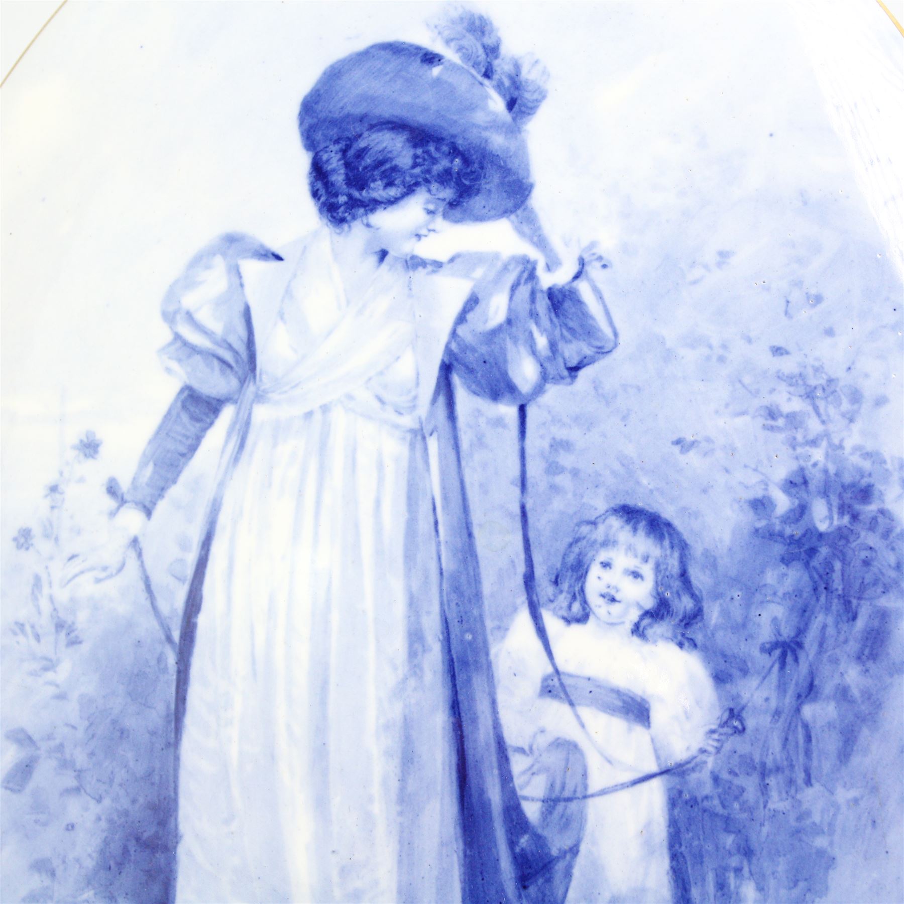 Doulton Burslem oval plaque, printed and painted with a mother and child withing a gilt border, 35cm x 27.5cm 