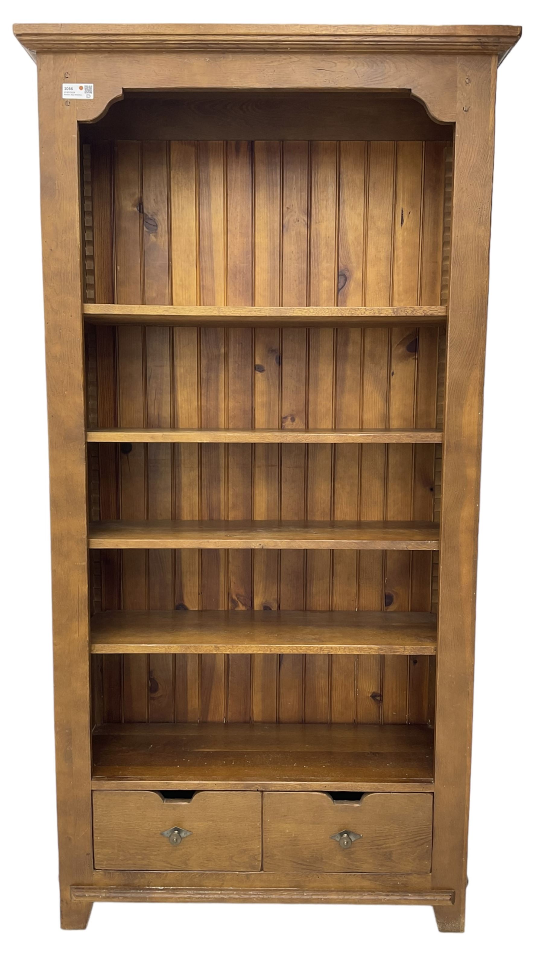 John Lewis - 'Bergerac' oak bookcase, projecting moulded cornice over four adjustable open shelves, two drawers to the base with cut-out handles, on square tapered supports