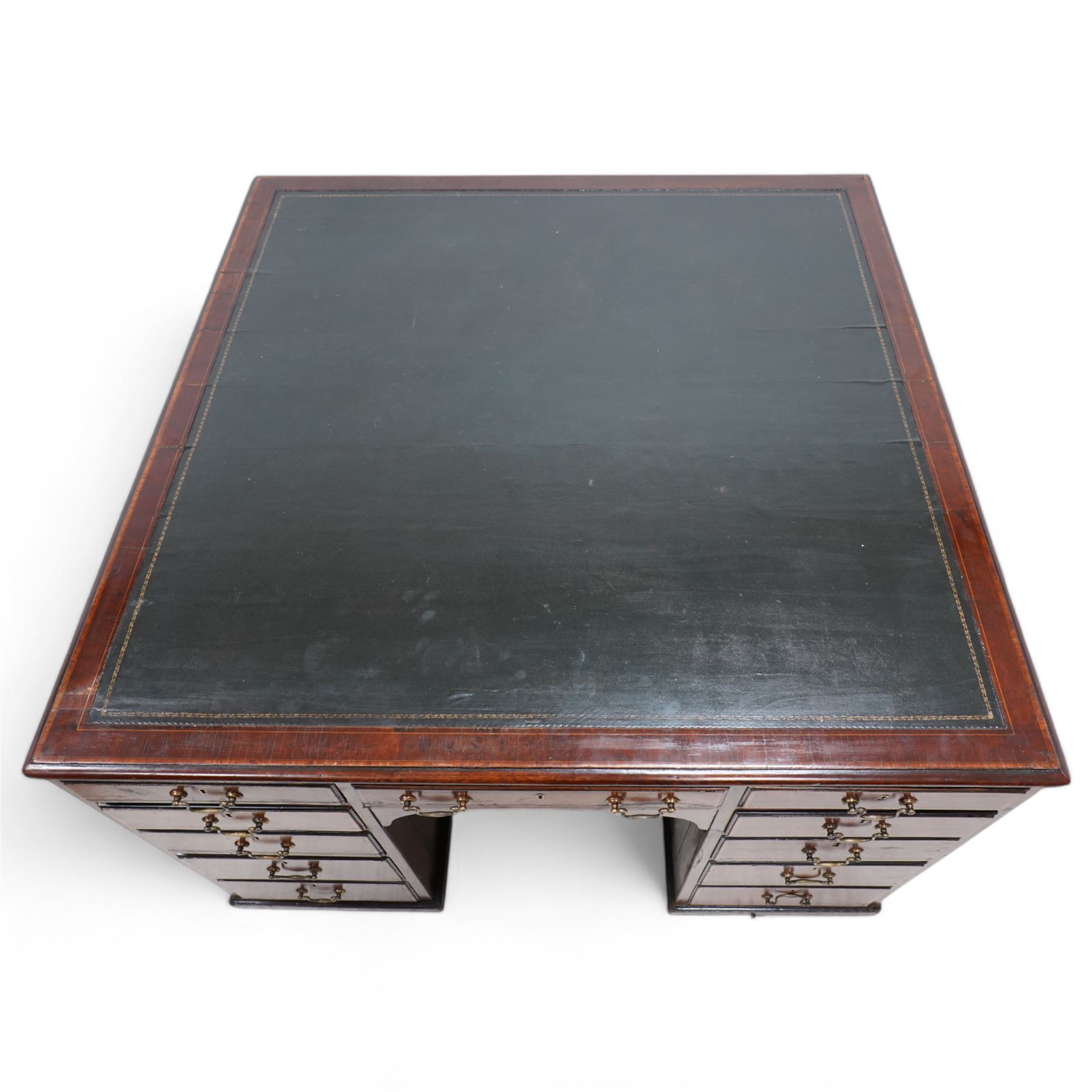 19th century inlaid mahogany kneehole desk, moulded rectangular top with inset leather writing surface and satinwood band, one side fitted with eleven drawers and panelled cupboard, the opposing side with kneehole fitted with eleven drawers and double cupboard, on skirted base with moulded edge 