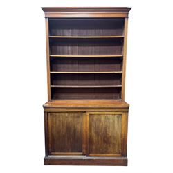 Early 19th century mahogany bookcase on cupboard, projecting cornice over four adjustable ...