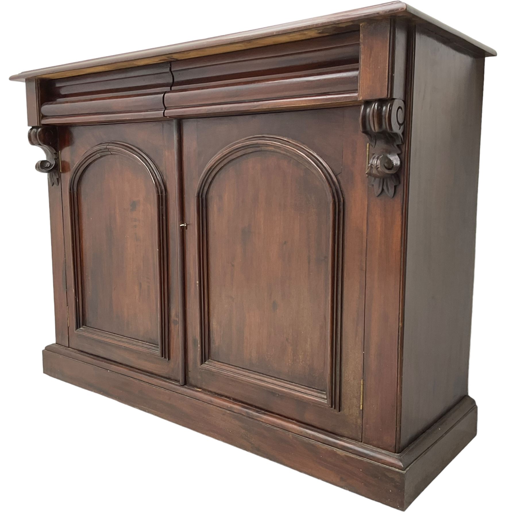 Victorian mahogany chiffonier, raised shaped back with foliage scroll carved mounts, on fretwork and carved bracket supports, moulded rectangular top over two frieze drawers and double panelled cupboard, on moulded plinth base