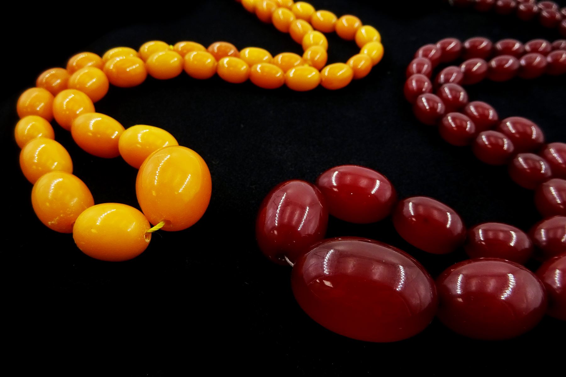 Single strand graduated oval amber bead necklace and a cherry amber type bead necklace