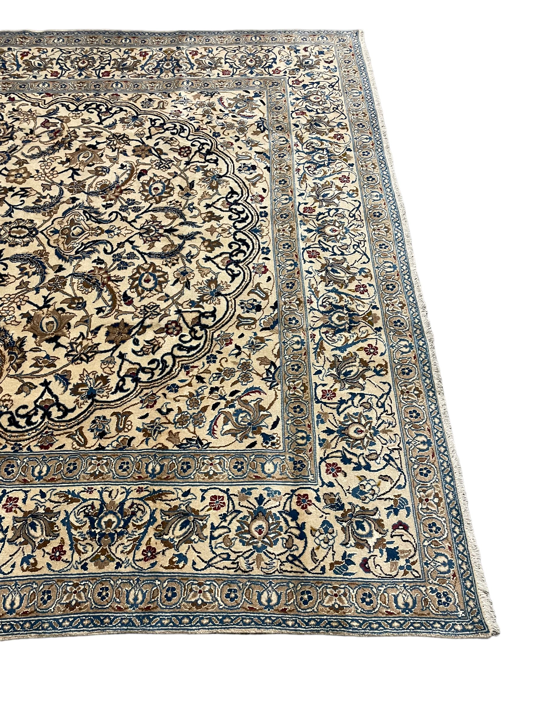 Persian ivory ground carpet, overall floral pattern with central rosette medallion, the field decorated with interlaced leafy branches and stylised plant motifs, guarded repeating border with repeating design