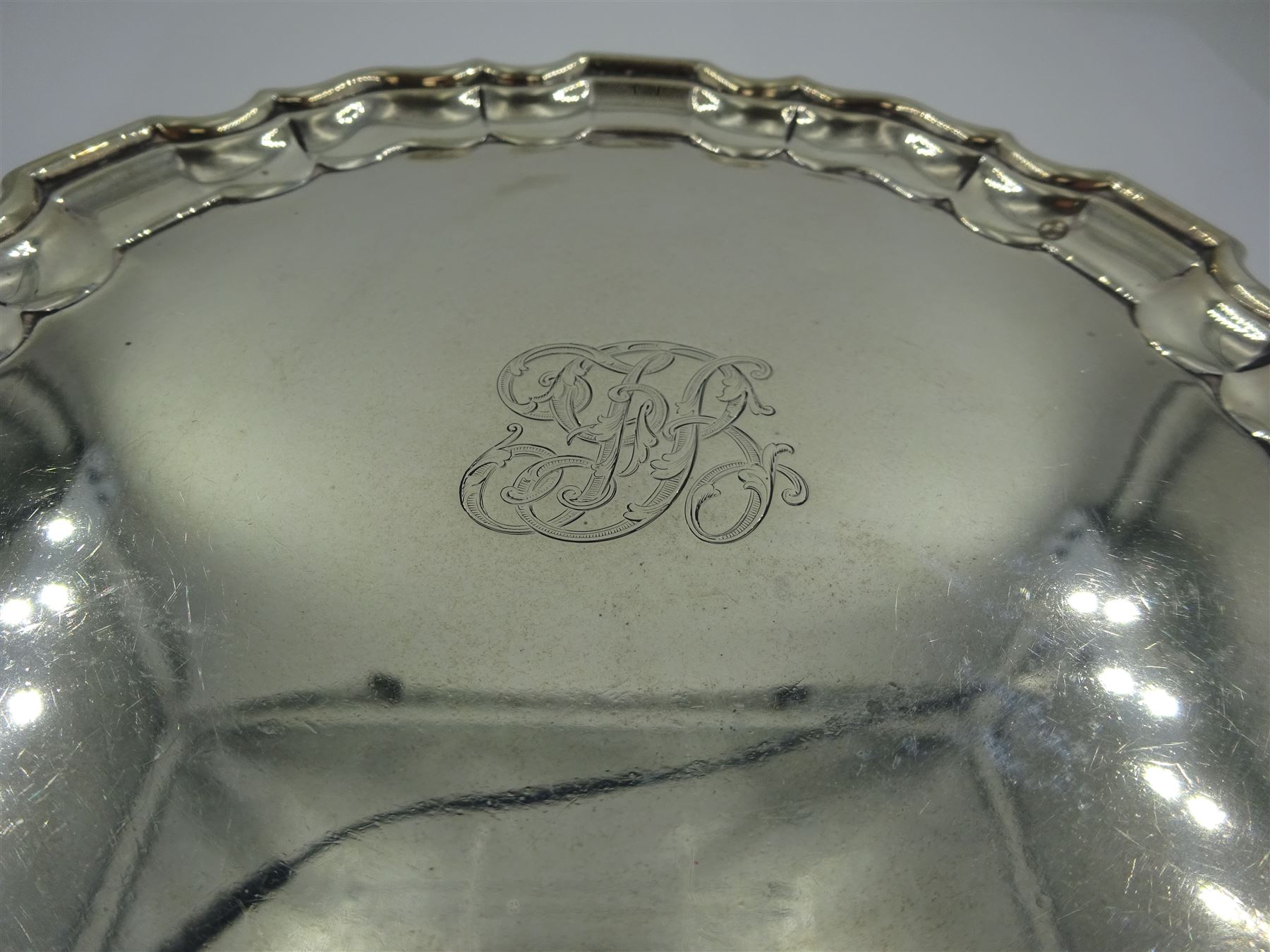 Early 20th century silver waiter, of circular form with pie crust rim, engraved with monogram to centre, upon three foliate feet, hallmarked Thomas Bradbury & Sons Ltd, London 1911, D15.5cm