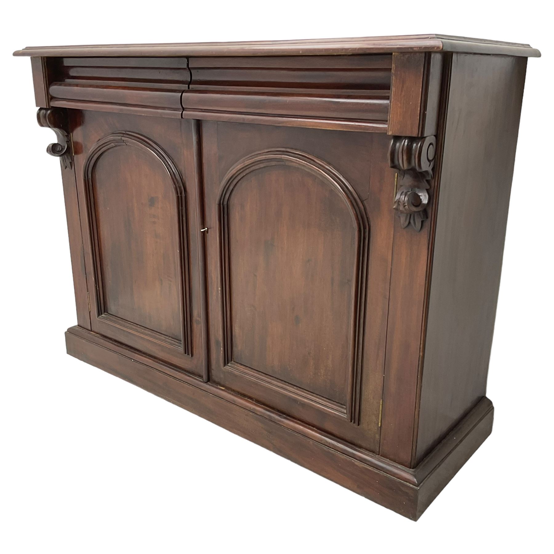 Victorian mahogany chiffonier, raised shaped back with foliage scroll carved mounts, on fretwork and carved bracket supports, moulded rectangular top over two frieze drawers and double panelled cupboard, on moulded plinth base