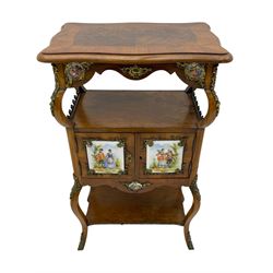 Mid-to-late 20th century French figured walnut three-tier bedside stand, shaped moulded top inlaid with figured book-matched veneers and crossbanding, double cupboard below enclosed by two doors mounted by painted porcelain panels depicting courting scenes within landscapes, on cabriole supports united by undertier, decorated with ornate cast metal cartouche mounts 