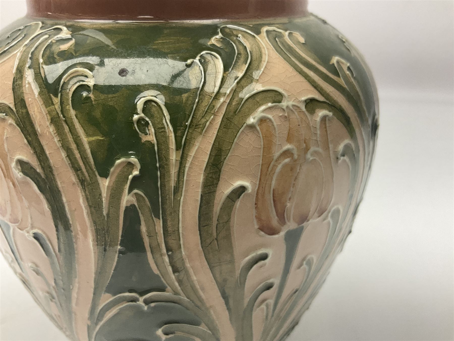 Moorcroft Macintyre Burslem jug, circa 1902, decorated with a motif of stylised flowers amongst scrolling foliage, in shades of brown and green on a peach ground, with printed mark beneath, H16cm