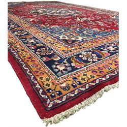 Persian Meshed red ground rug, central floral rosette medallion surrounded by trailing branch and stylised flower heads, repeating scrolling border