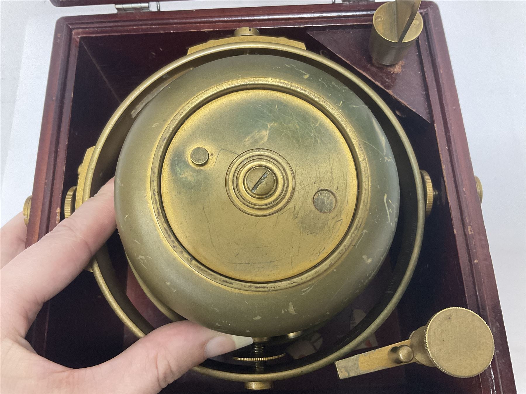 Two-day marine chronometer, with silvered dial inscribed Thomas Mercer Ltd, St Albans, contained within a brass gimbal-mounted bowl and glazed mahogany case, with applied brass plaque reading 'supplied by Kelvin Hughes no. 24295', brass winding key and two service notes to interior of case, dial D12cm, wooden case H17.5cm 