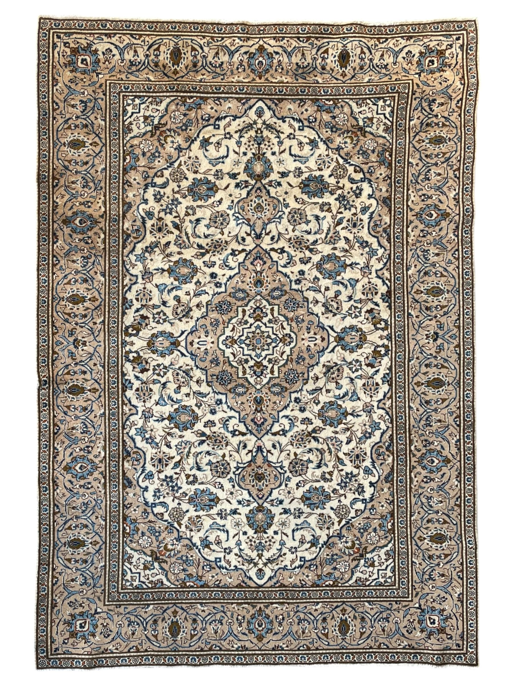 Persian Kashan ivory ground rug, the field decorated with interlacing branches and palmettes, central floral design pole medallion, the scrolling border decorated with stylised plant motifs, within repeating flower head guard stripes