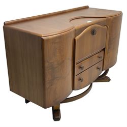 Beautility - mid-20th century walnut sideboard, fall-front with sliding top enclosing mirror interior, fitted with two drawers and flanking cupboards, on sledge feet with curved stretchers 