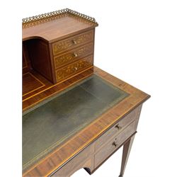 Edwardian inlaid mahogany writing desk, raised galleried back over inlaid central urn with scrolling leafy branches and six small drawers, satinwood banded rectangular moulded top with tooled leather inset, fitted with five drawers, the drawer facias inlaid with scrolling foliage and satinwood banding, square tapering supports inlaid with trailing bell flowers, on brass and ceramic castors 