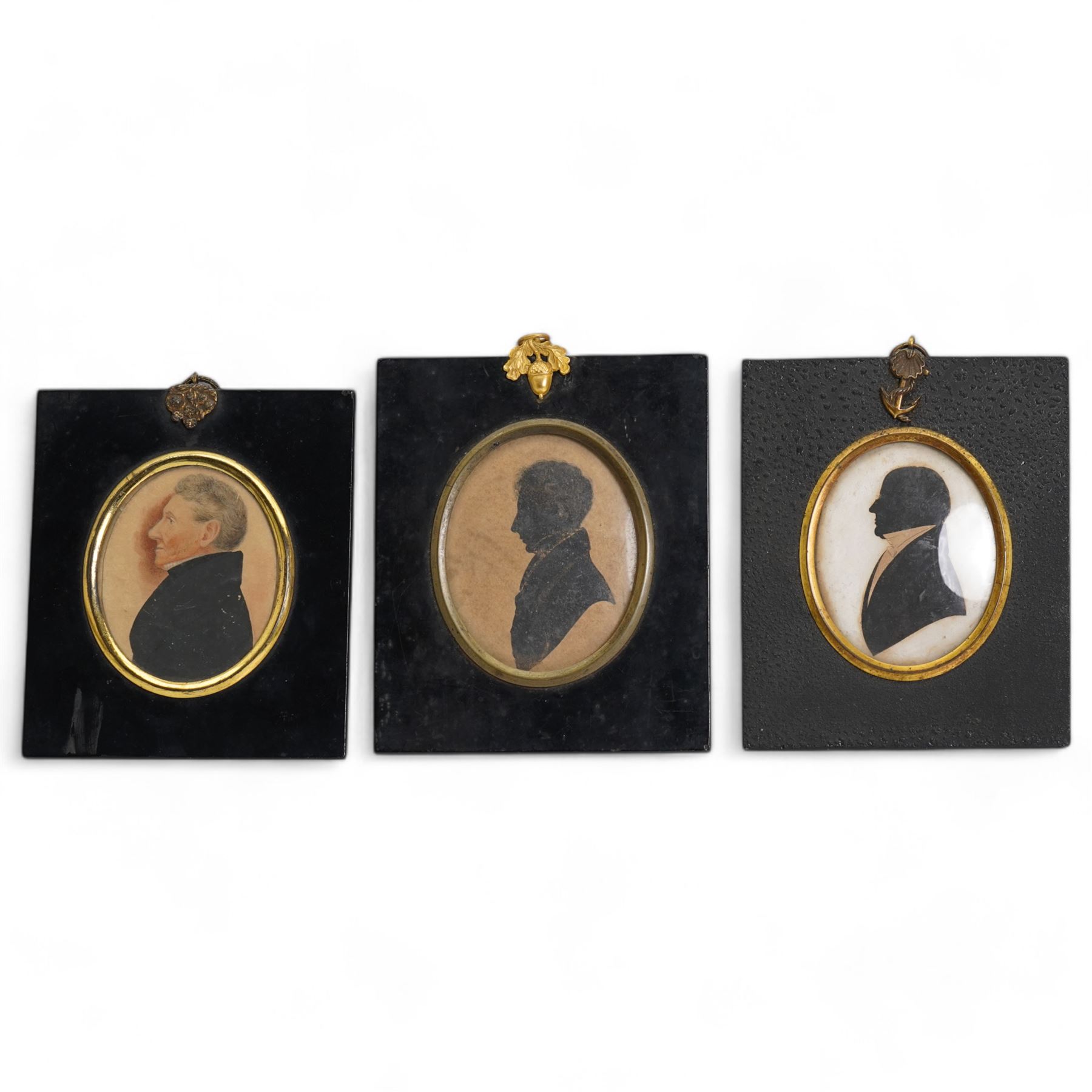 Two 19th century oval silhouettes of members of the Hamilton family, possibly Henry Hamilton (Irish c.1780-1850) and Sackville Hamilton (Irish 1732-1818), in ebonised frames; together with another similar with hand-colouring, indistinctly inscribed verso 13cm x 11cm (3)