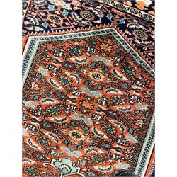 North West Persian Bidjar rug, orange peach ground extended field on indigo ground, decorated with floral Herati motifs, repeating waved border decorated with stylised plant motifs