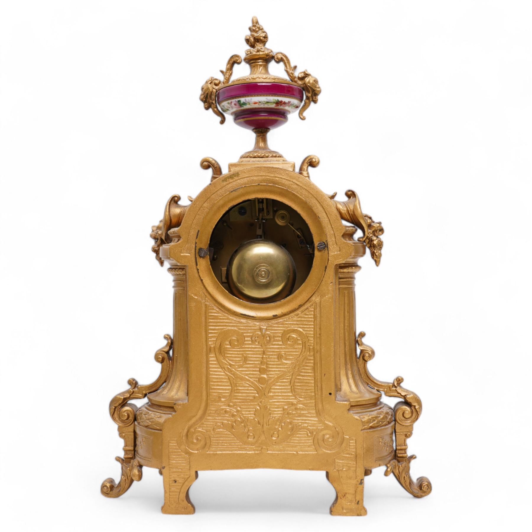 French - Late 19th century 8-day gilt metal and porcelain mounted clock c1880, the arched case above a plinth base on paw feet surmounted by an urn, porcelain dial with cartouche Roman numerals and steel spade hands, twin train rack striking movement, sounding the hours and half hours on a bell. With pendulum. 