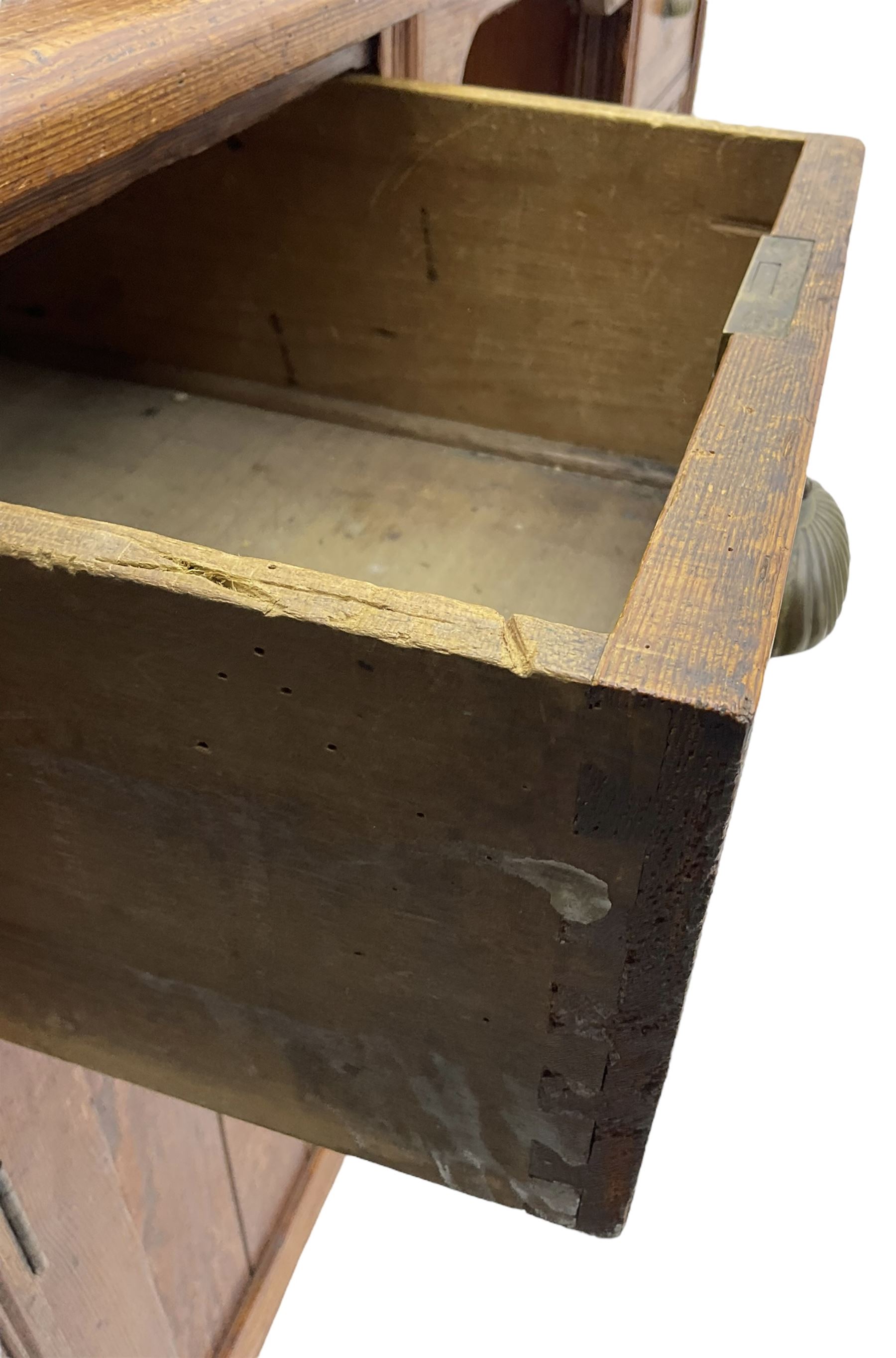 Edwardian pitch pine desk, rectangular top with writing slope flanked by inset leather writing surfaces, over twin pedestals each with shell cup handled drawer over cupboard, the left enclosing two shelves, the right enclosing sliding trays, on fluted straight supports