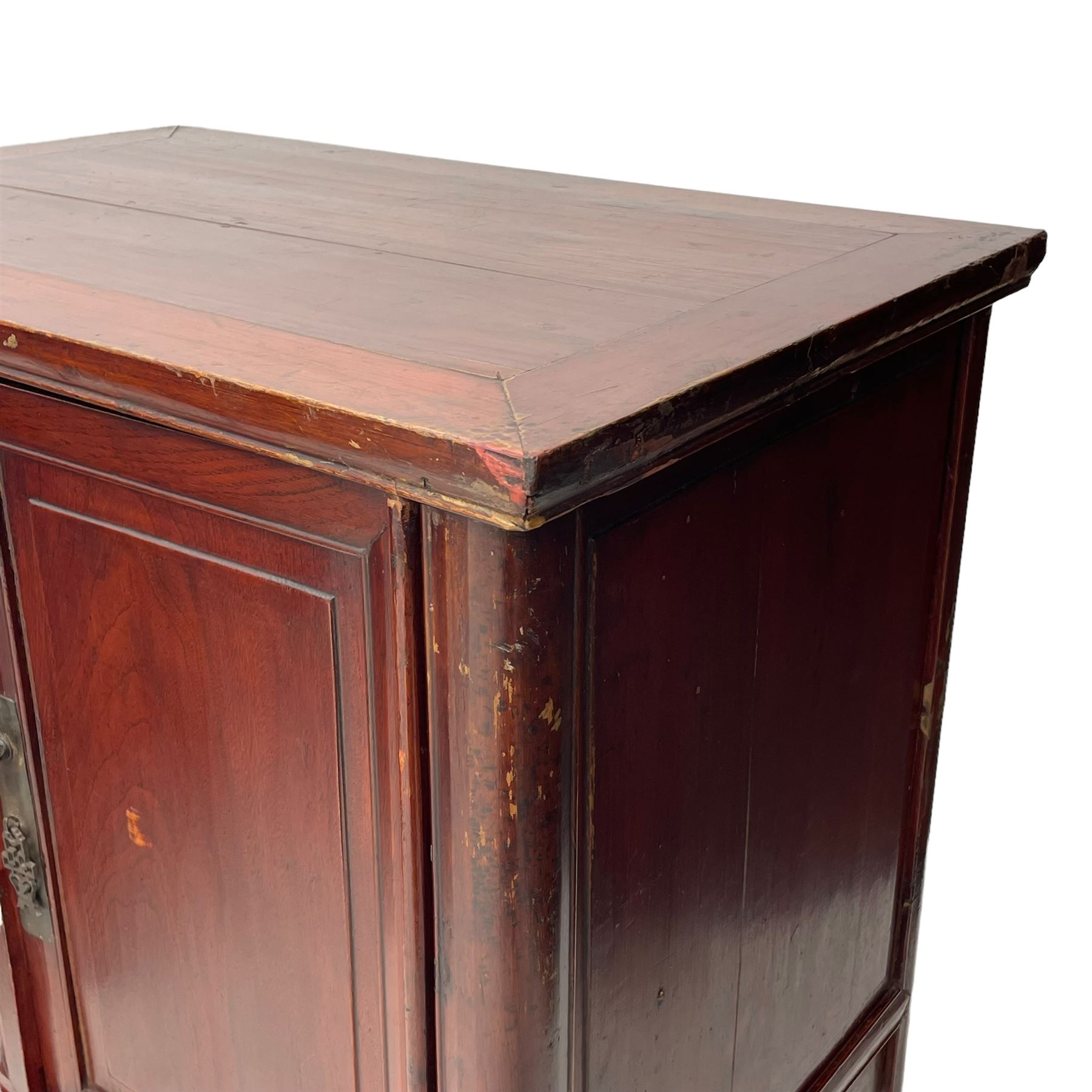 Pair of early 20th century Chinese red lacquered elm storage cupboards, rectangular top over two panelled doors, fitted with two internal drawers, on square supports with curved outer edge, panelled sides