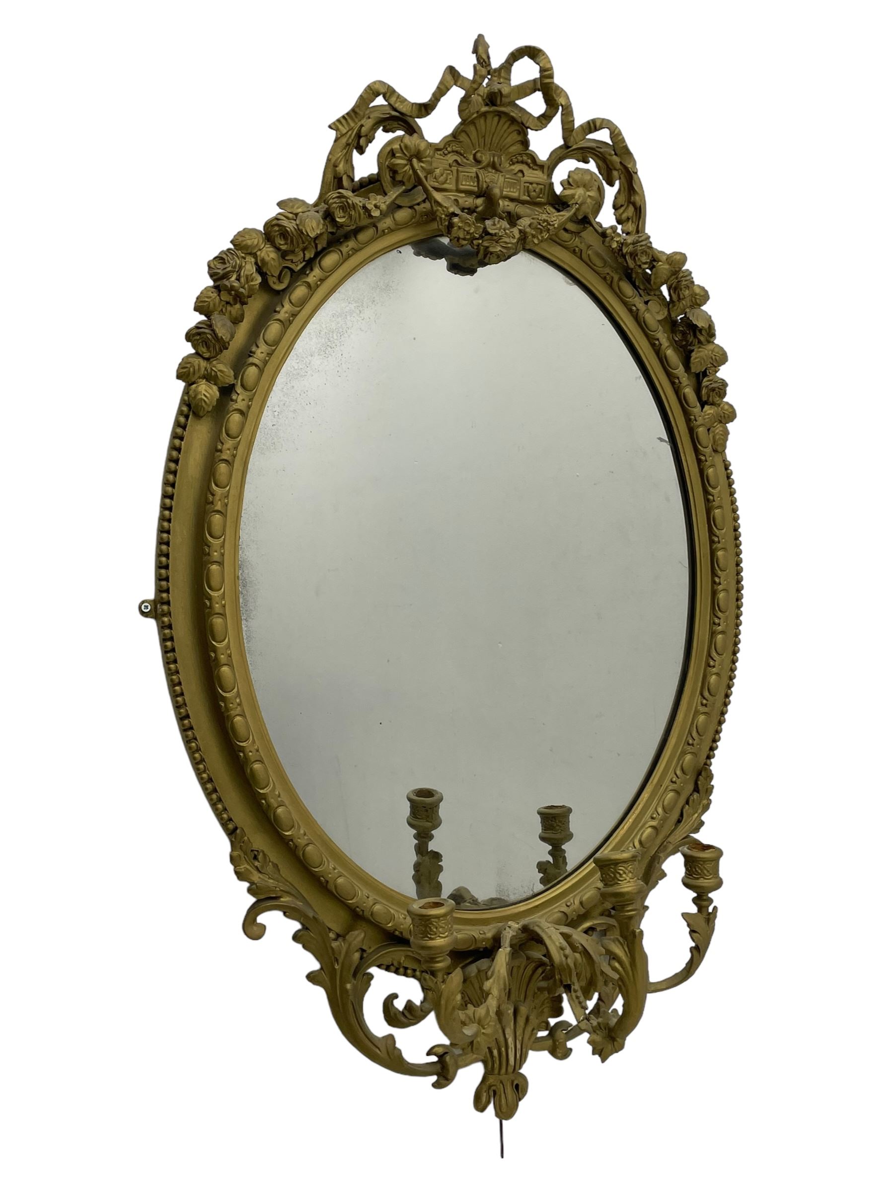 19th century giltwood and gesso girandole wall mirror, the raised pediment decorated with ribbon tie over curled acanthus leaves and flowerhead festoons, oval egg and dart moulded frame with outer bead, three projecting candle sconces in the form of scrolled acanthus leaves, lower shell motif with extending leaf decoration 