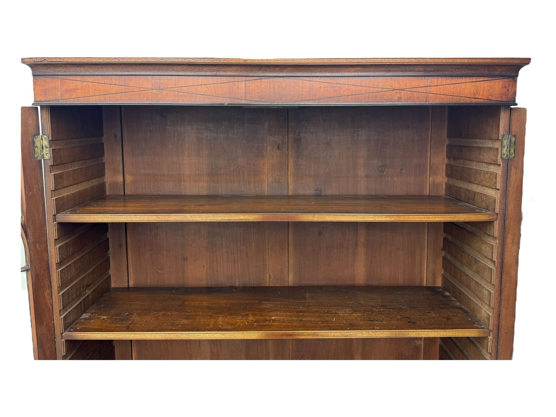 Early 19th century mahogany bureau bookcase, the projecting cornice over two Gothic-style astragal glazed doors enclosing two adjustable shelves, sloped hinged lid enclosing fitted interior and felt inset, four graduating drawers, on bracket feet