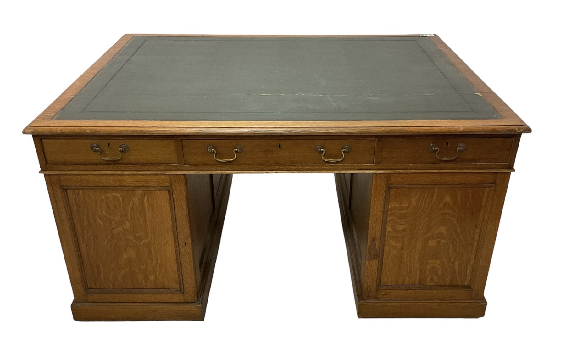 Late 19th century twin pedestal oak partner's desk, rectangular top with inset green leather writing surface, fitted with nine graduating drawers to each side, the rear drawers enclosed by panelled cupboards