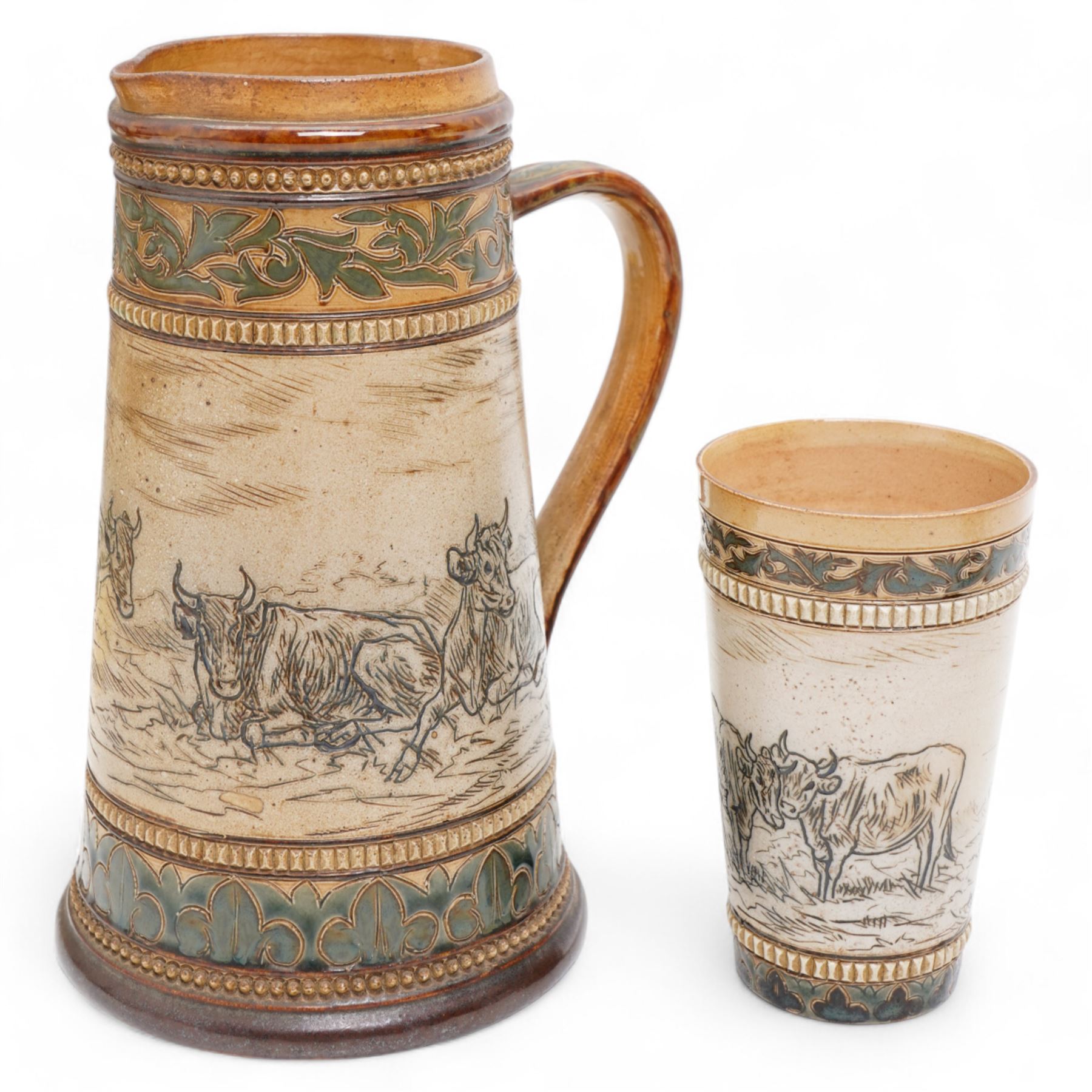 Late 19th century Doulton Lambeth sgraffito jug and beaker by Hannah Barlow, decorated with bands of cattle in landscapes between foliate boarders, with impressed and incised marks beneath, including monogram H24cm (2)