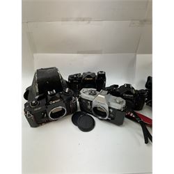 Four Canon SLR camera bodies, to include F-1 serial no. 273243, A-1 serial no. 1818620, EF serial no. 317419, all in black finish, with Canon cases, and an FT serial no. 251226 in black and silver finish