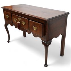 18th century oak dresser base, the rectangular top with moulded edge, fitted with three drawers with original brass handle plates, over a shaped frieze, raised on front cabriole supports with pad feet