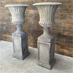 Pair of large Georgian design cast stone garden urns, egg and dart border, tapering column on square base, raised on square column