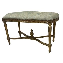 French Louis XIV design giltwood framed bench or window seat, sprung seat upholstered in pale blue foliate damask fabric with studwork border, raised on gesso moulded and carved tapering supports united by curved X-stretcher, with central acanthus carved finial