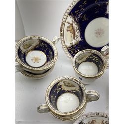 19th century part tea service, comprising tea cups of two sizes, saucers, cake plate, and cream jug, painted with landscapes in reserves against a cobalt blue band heightened with gilt, in one box 