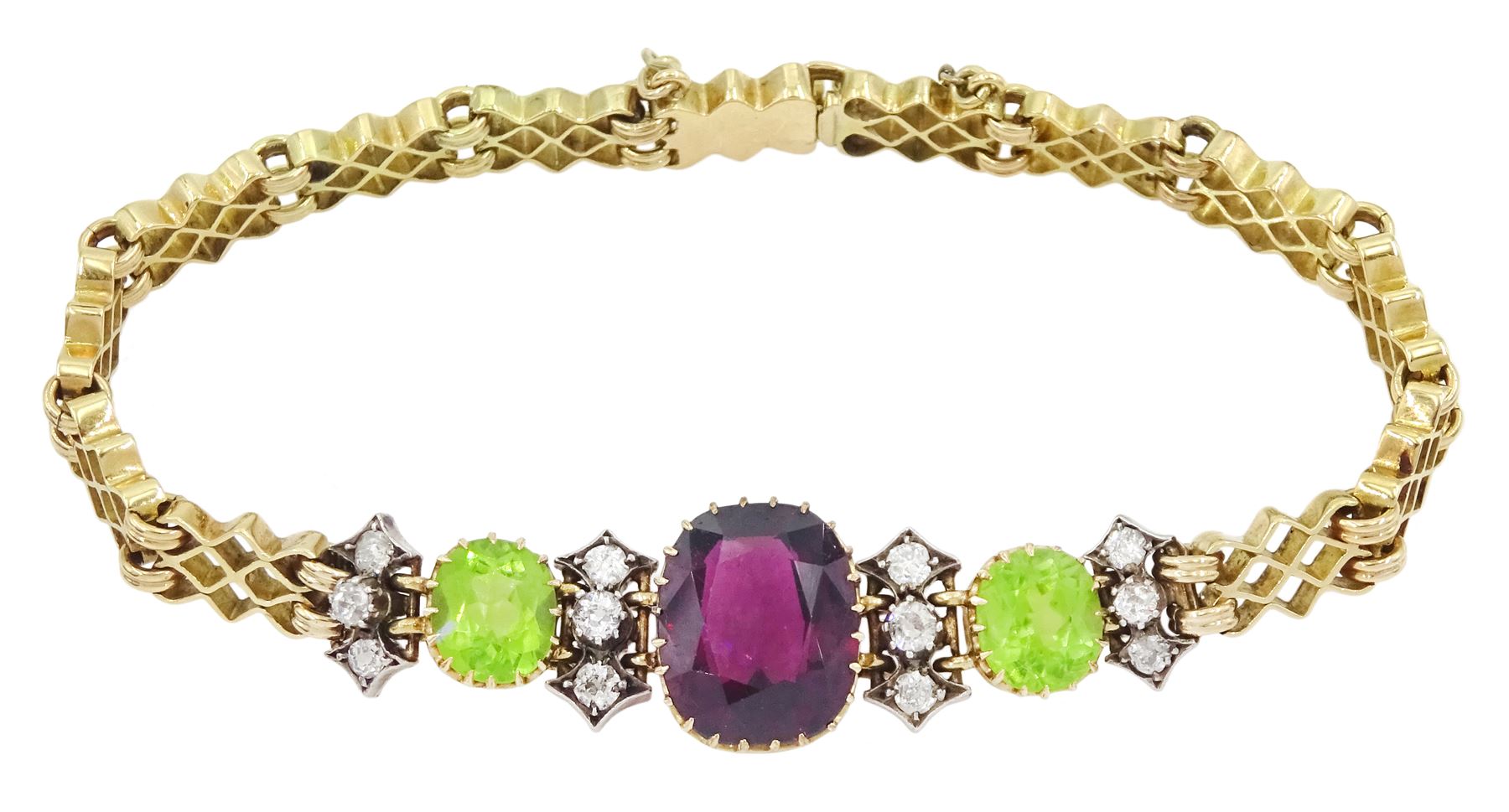 Early 20th century 15ct gold garnet, peridot and diamond, fancy link chain bracelet, the central cushion cut rhodolite garnet of approx 5.05 carat, with two cushion cut peridots set either side, spaced by three old cut diamonds, total diamond weight approx 0.35 carat, in fitted case by Garrard & Co