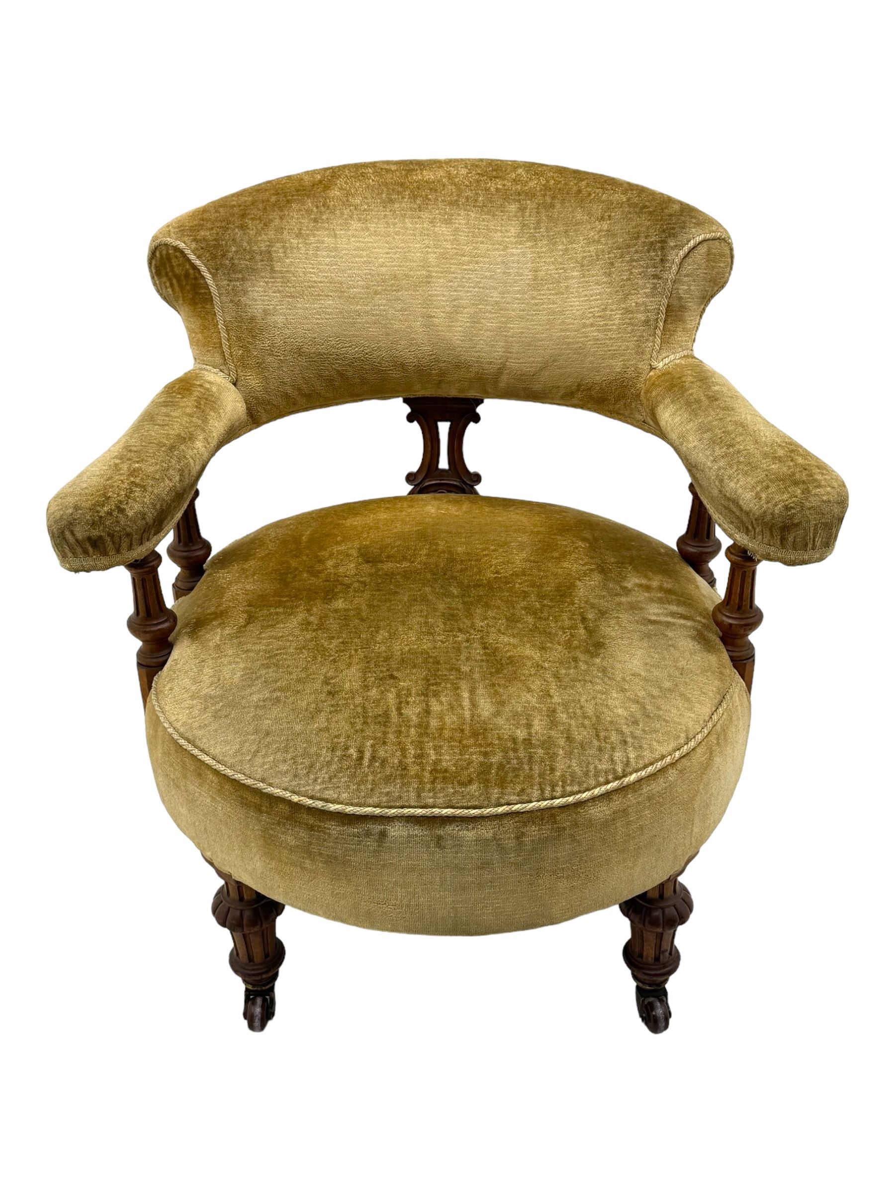 Victorian pair of mahogany armchairs, upholstered in gold velvet fabric, each with curved back, pierced splat and scroll arms, one with rounded seat and the other square, on turned front supports with castors