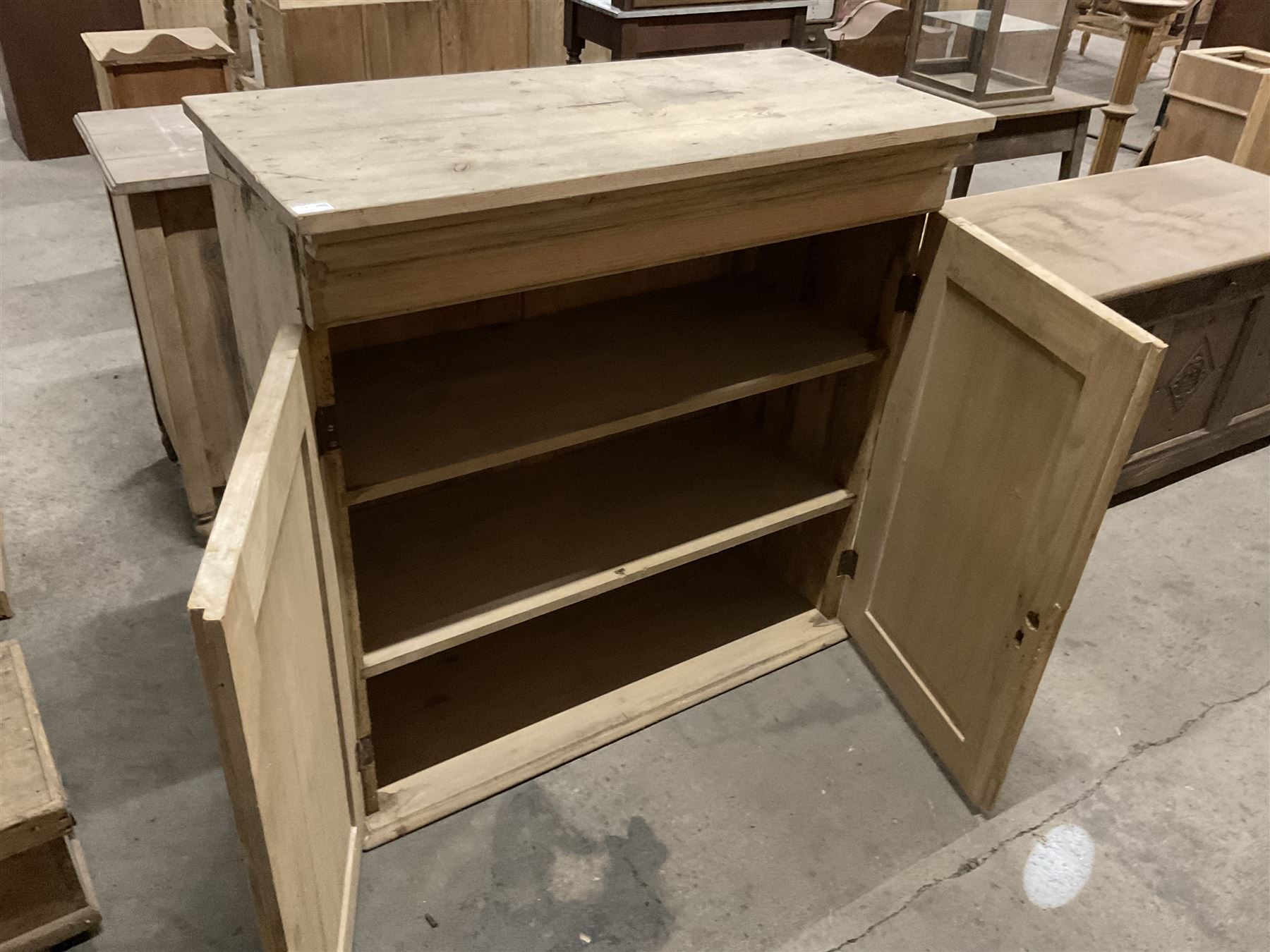 Stripped pine cupboard or bookcase, projecting cornice over two panelled doors, enclosing two shelves - THIS LOT IS TO BE COLLECTED BY APPOINTMENT FROM THE OLD BUFFER DEPOT, MELBOURNE PLACE, SOWERBY, THIRSK, YO7 1QY