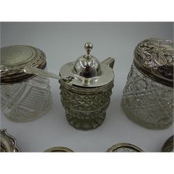 George III silver mounted cut glass mustard pot with cover, the cut glass body with silver domed cover engraved with monogram and angular handle, hallmarked London 1807, maker's mark indistinct, together with two cut glass jars with silver covers, two cut glass salts with silver collars, a silver bon bon dish and a silver ashtray, all hallmarked 